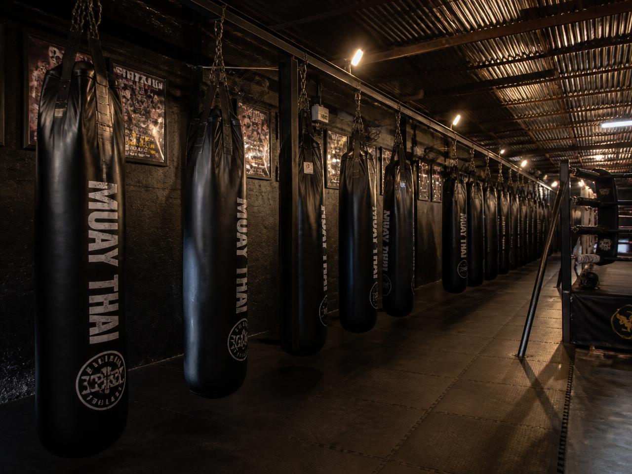 Sacos de pancada alinhados em academia de Muay Thai